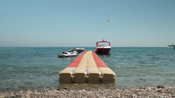 Empty floating pontoon on sea water surface with moored jet bike and small yacht — Vídeo de stock