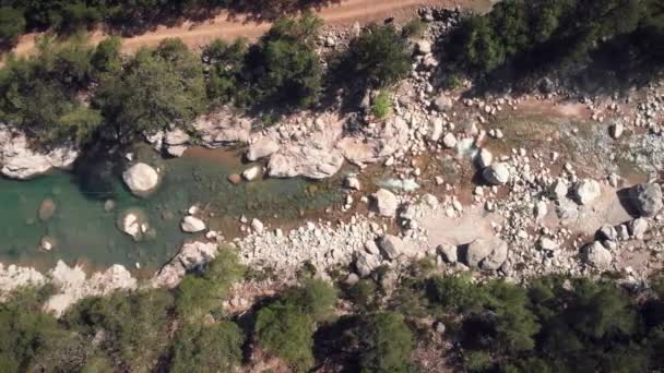 Rzeka górska z turkusową wodą opadającą w kaskadach między mokrymi kamieniami — Wideo stockowe