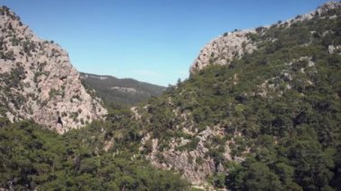 Yüksek irtifa manzarası ve kayalık dağ zirveleri. Dağlardaki ladin ormanları