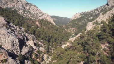 Güneşli yaz gününde yüksek rakımlı dağ sıraları. Büyük dağ vadisinin üzerinden uçuyor.