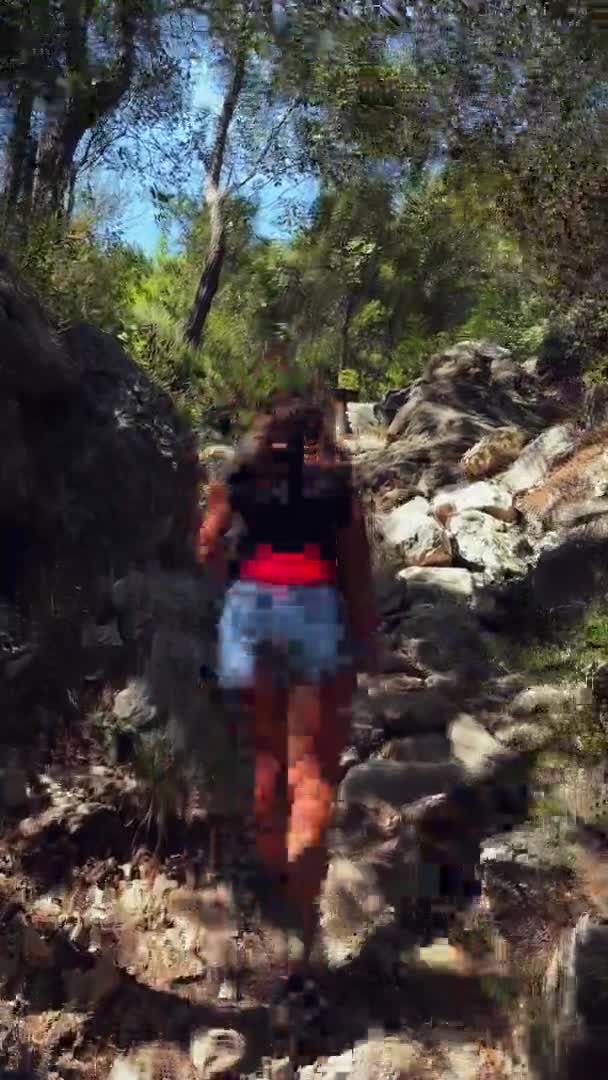 Γυναίκα πεζοπορία στο δάσος και το περπάτημα μέσα από μεγάλες πέτρες και βραχώδη βουνά — Αρχείο Βίντεο
