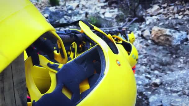 Protective helmets to practice rafting hanging on wall near mountain lake — Video Stock