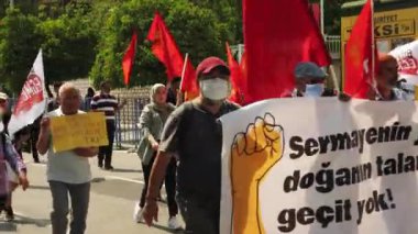 Antalya, Türkiye 'deki gösteri mitinginde kırmızı bayraklarla yürüyen insanlar, 01.05.22