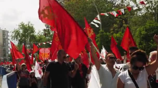 People with red flags walk on street at protest rally, Antalya,Turkey,01.05.22 — Stock Video