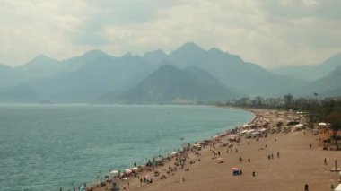 Yaz sıcağında sahildeki insanlar. Deniz ve dağlarla dolu inanılmaz kıyı şeridi.