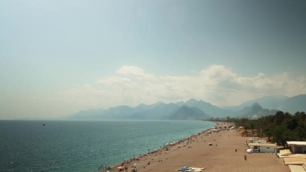 Ondas oceânicas e praia de areia com pessoas tomando banho na água no dia ensolarado de verão — Vídeo de Stock