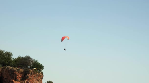 Red parachute flying over sea water surface. Paragliding across seaside — 비디오