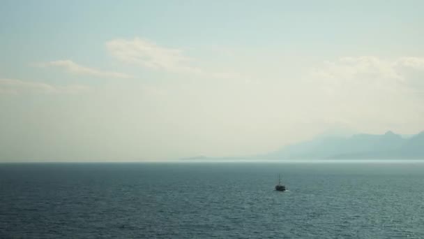 Barco de pesca flutuando na lagoa do mar. Navio navegando no lago com colinas de montanha — Vídeo de Stock