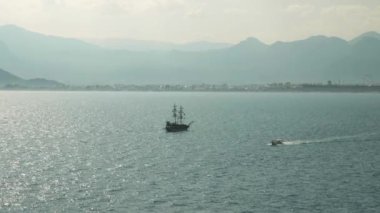 Deniz manzaralı güzel deniz manzarası, yüzen tekneler ve arka planda dağlar.