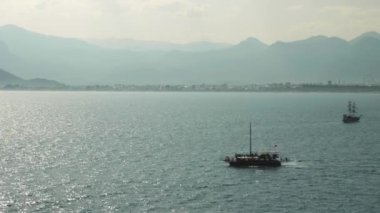 Yazın gölde yüzen balıkçı teknesi. Göl kenarında yelken açan korsan turist teknesi