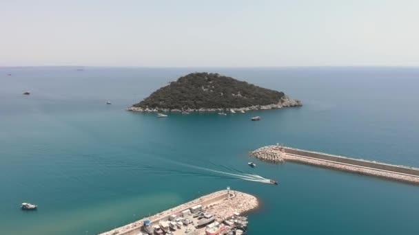Bateau flottant vers la marina. Paysage marin avec petite île, port et yachts amarrés — Video