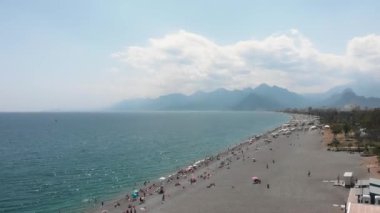 Geniş çakıl taşı plajı, sakin denizi ve dağları olan güzel sahil şeridi.