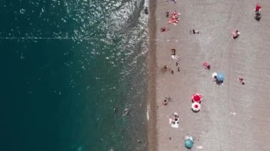 Akdeniz sahil şeridinin kumsalında. İnsanlar yazın plajda takılıyor.
