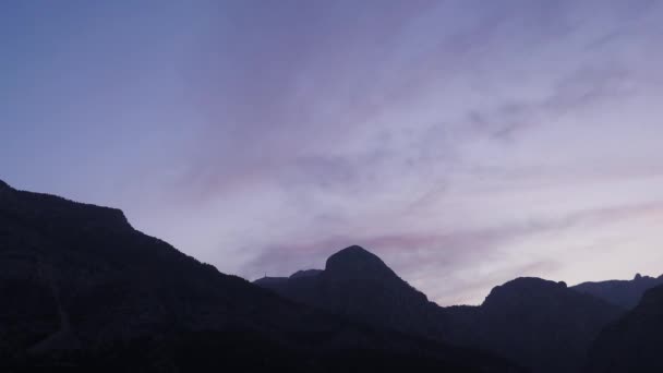 山の峰の上に絵のような夕日 山を背景に美しいピンクの夕日 時間の経過 野生の自然景観 日没と日の出 — ストック動画