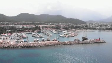 Kayalık sahillerde villaları olan küçük bir turizm şehrinin yakınındaki yat ve tekneler.