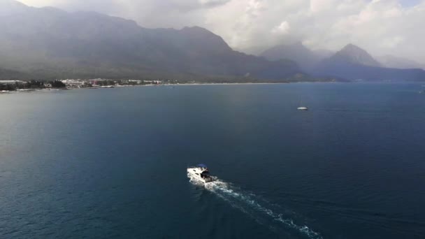 Cruise speed boat floating in sea along rocky coastline of Mediterranean Sea — Wideo stockowe