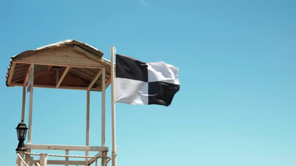 Vlag verbiedt zwemmen in zee vanwege watersportgebied.Waarschuwingsvlag wapperend in de wind — Stockvideo