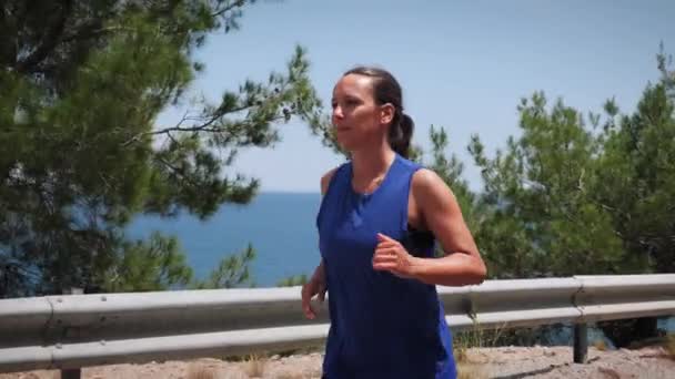 Femme sportive courant sur la route dans le littoral de montagne.Loisirs — Video