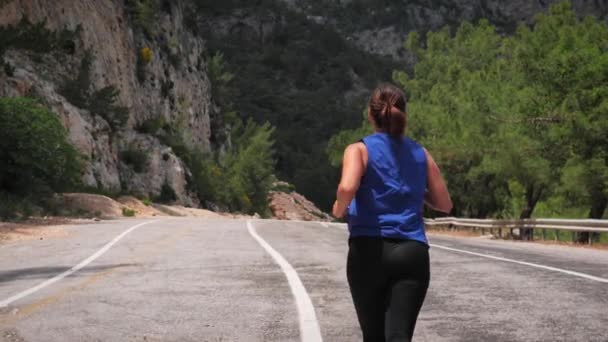 Young active woman running in mountains.Energetic fitness female jogging outdoor — Stockvideo
