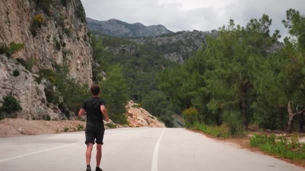 Triathlete training outdoors.Triathlon exercises.Man running through forest road — ストック動画