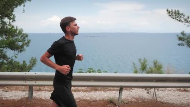 Jovem atlético a correr. Triatleta exercitando ao ar livre. Motivação física — Vídeo de Stock