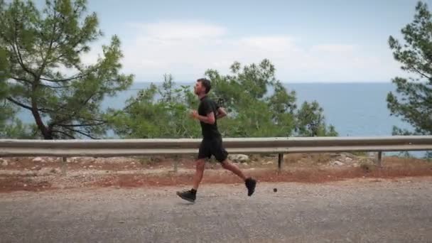 Концепція бігу та бігу. Тріатлоніст бігає на відкритому повітрі уздовж моря — стокове відео
