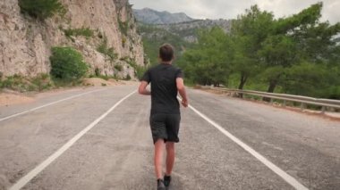 Fit young man running fast. Athlete training outdoors. Endurance runner jogging