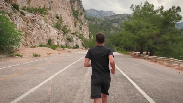 Hombre corriendo en el bosque. Concepto de trotar. Joven atlético masculino haciendo ejercicio al aire libre — Vídeo de stock