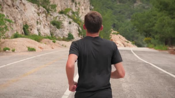 Hombre de fitness haciendo ejercicio al aire libre. Hombre atlético corriendo por el camino de la montaña en la mañana — Vídeo de stock