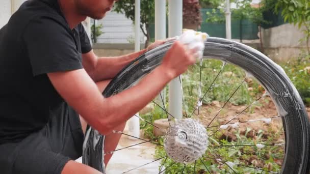 Ruota meccanica per lavaggio e pulizia biciclette. Uomo lava bici con panno — Video Stock