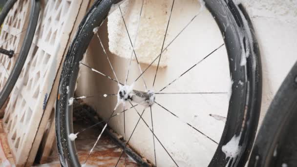 Bike mechanic washing bike spokes with soap and washcloth. Clean bicycle wheel — Vídeo de stock