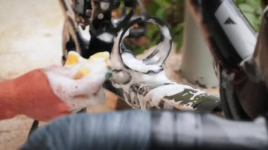 Bicycle washing and cleaning. Male hands washing bike with soap and washcloth