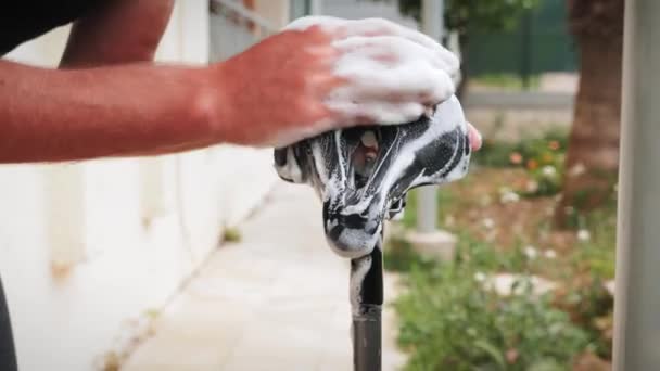 Homme lavant selle de vélo à l'extérieur. Mécanicien de vélo nettoyage vélo après la saleté — Video