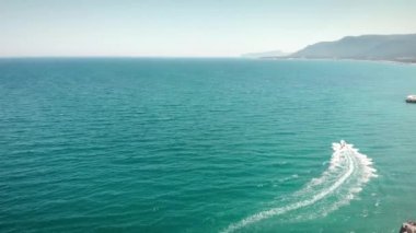 Lüks sürat teknesi turkuaz gölde yüzüyor. Denizde giden beyaz sürat teknesi