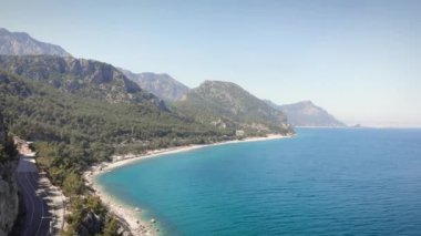 Yeşil tepeleri ve berrak deniz suyuyla dağlık kayalık kıyı şeridi. Tropik deniz kıyısı