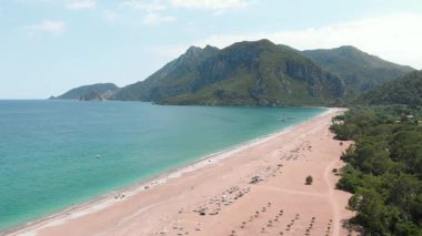 Sakin turkuaz suyu ve geniş kumlu plajı olan tropik ada gölü.