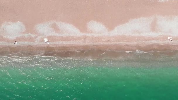 Прозорі бірюзові морські хвилі ламаються на піщаному пляжі, розбризкуючи створюючи білу піну — стокове відео
