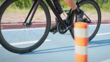 Triatlon ve bisiklet konsepti. Bisikletçi sabah bisiklet yolunda bisiklet sürüyor. Profesyonel kadın triatlet bisikletle pedal çeviriyor, bisiklet yarışlarına hazırlanıyor, yoğun kardiyo egzersizi yapıyor.