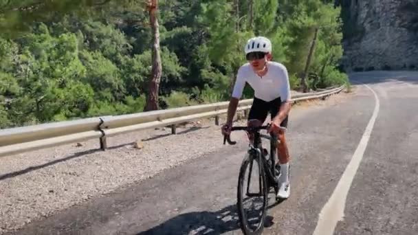 在森林里骑自行车的人骑自行车 职业自行车运动员在自行车上训练 做有氧耐力锻炼 男子运动员骑自行车在山顶上 体育概念 — 图库视频影像