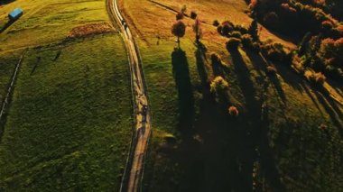 İnsanlar gün batımında dağ sıraları boyunca kirli kırsal alanlarda arazi araçlarına biniyorlar. Gezginler doğa dağ manzarasını ve ormanı keşfeder. Dörtlü bisiklet kullanan ATV sürücüleri