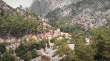 Dağ virajı yolu. Yeşil kayalık dağlarda boş asfalt yol. Ulaşım konsepti. Nehirli güzel dağ manzarası