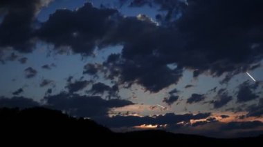 Günden geceye inanılmaz bulutlu bir geçiş. Altın gün batımında kabarık bulutlar. Gün batımında mavi gökyüzüne doğru hızla hareket eden bulutlar. Güzel akşam alacakaranlığı