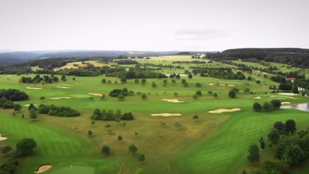 有高尔夫球孔和小山的绿色高尔夫球场 用绿草在高尔夫球场上空飞舞 — 图库视频影像