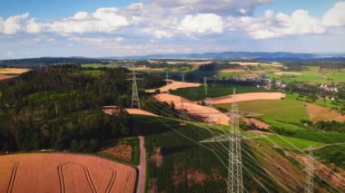 Kırsal alanlarda elektrik hatları olan iletim kuleleri. Elektrik direkleri kablolarla desteklenir. Yüksek voltajlı güç kuleleri. Çevresel koruma. Enerji endüstrisi
