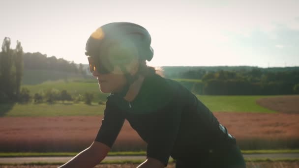 Γυναίκα Ποδηλάτης Πρόσωπο Κράνος Και Γυαλιά Ηλίου Ποδηλασία Στο Ηλιοβασίλεμα — Αρχείο Βίντεο