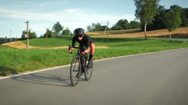 Rennradfahrerin Die Bei Sonnenuntergang Auf Einer Schönen Asphaltierten Straße Inmitten — Stockvideo