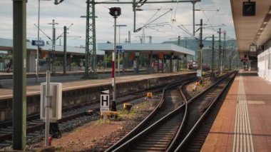 Tren tren istasyonuna giriyor. Modern yolcu treni tren istasyonuna geliyor. Demiryolu rayları olan boş bir istasyon platformu. Ulaşım ve lojistik kavramı