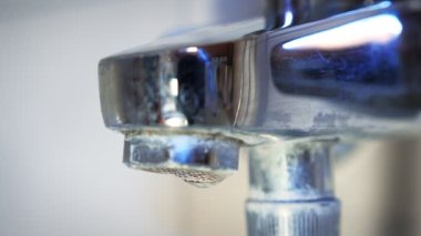 Water dripping from broken faucet in bathroom, close up of shower crane. Water drops from bathroom crane