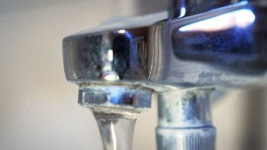 Opening water in faucet in bathroom. Hand turning water on in shower faucet. Close up of bathroom crane with flowing water