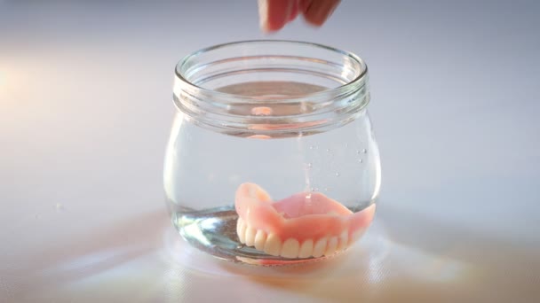 Hand Taking Artificial Teeth Out Glass Water Dental Implants Hygiene — Video